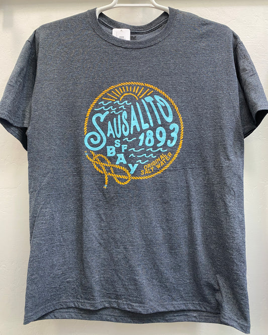 A heather grey crewneck t-shirt featuring a vibrant orange and teal screen-printed graphic on the chest. The design showcases the text "Sausalito SF Bay 1893 Original Salt Water" surrounded by stylized ocean waves, a rising sun, and a nautical rope border tied into a distinct figure-eight knot.