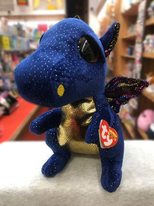 Ty Beanie Boo Saffire blue dragon plush with gold speckles and glittery wings, sitting on display in a toy store