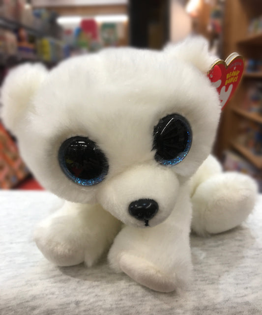 Ty Beanie Baby Ari white polar bear plush with bright blue glittery eyes, soft fur, and red heart tag, on display in toy store