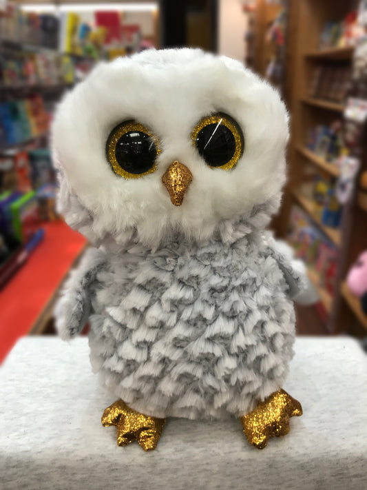 Ty Beanie Boo Owlette plush: white and gray owl with large sparkly gold eyes, golden beak and feet, in a toy store setting