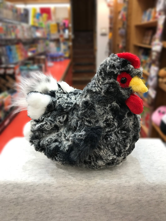 Realistic black hen plush toy with salt-and-pepper feathers, red comb and wattle, displayed in a toy store setting