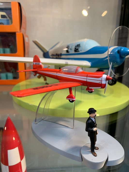 De Havilland Chipmunk model from Tintin's Black Island, red plane on display with blue aircraft and character figurine