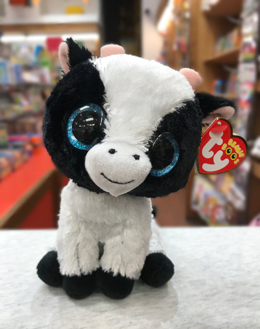Cute Ty Beanie Boo Butter Cow plush toy with large sparkly blue eyes, black and white fur, and red Ty heart tag, sitting on display