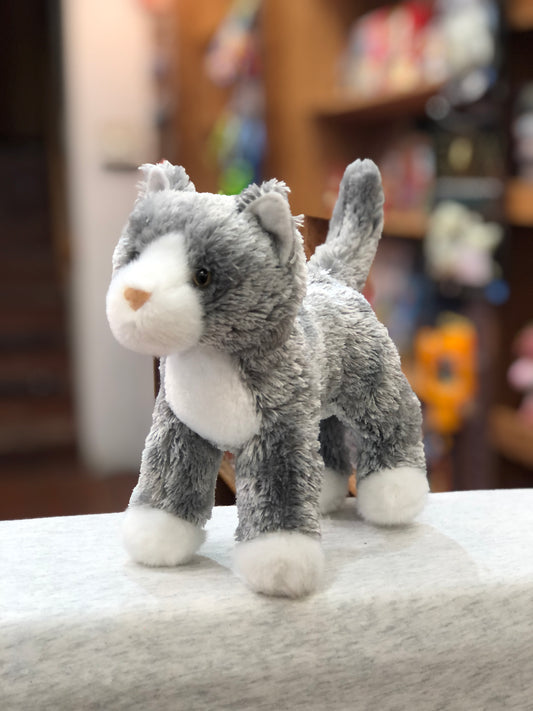 Soft gray cat plush toy with white markings, standing on display with bright eyes and pink nose, 6 inches tall