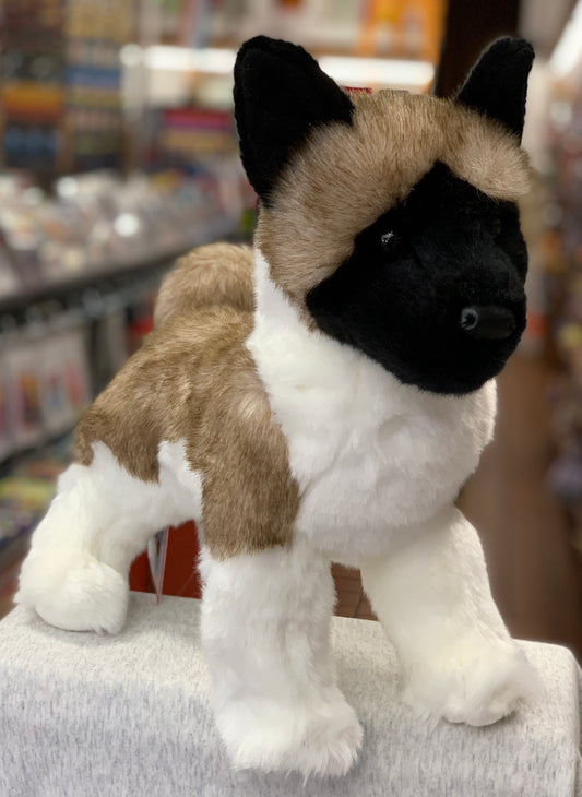 Lifelike Akita dog plush toy with white, brown, and black fur, standing on display in a store setting