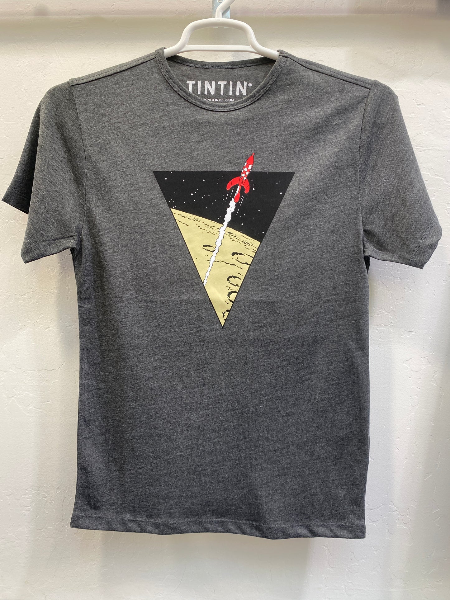 Grey unisex Tintin t-shirt featuring a triangular graphic of the red-and-white Moon Rocket launching from the lunar surface into space.